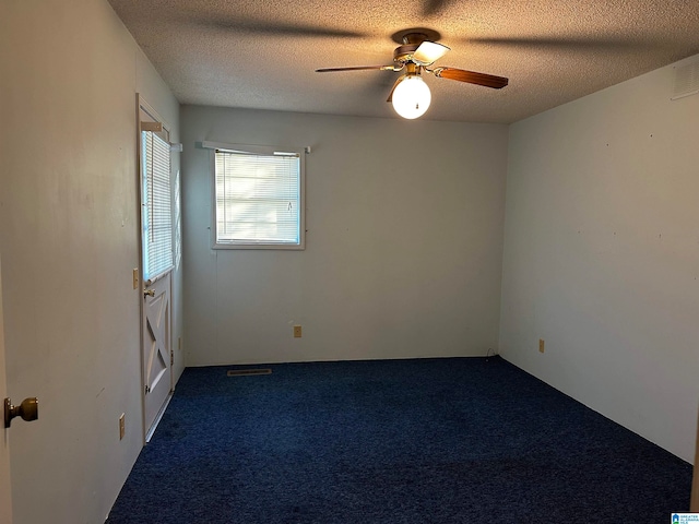 carpeted spare room featuring ceiling fan and a textured ceiling