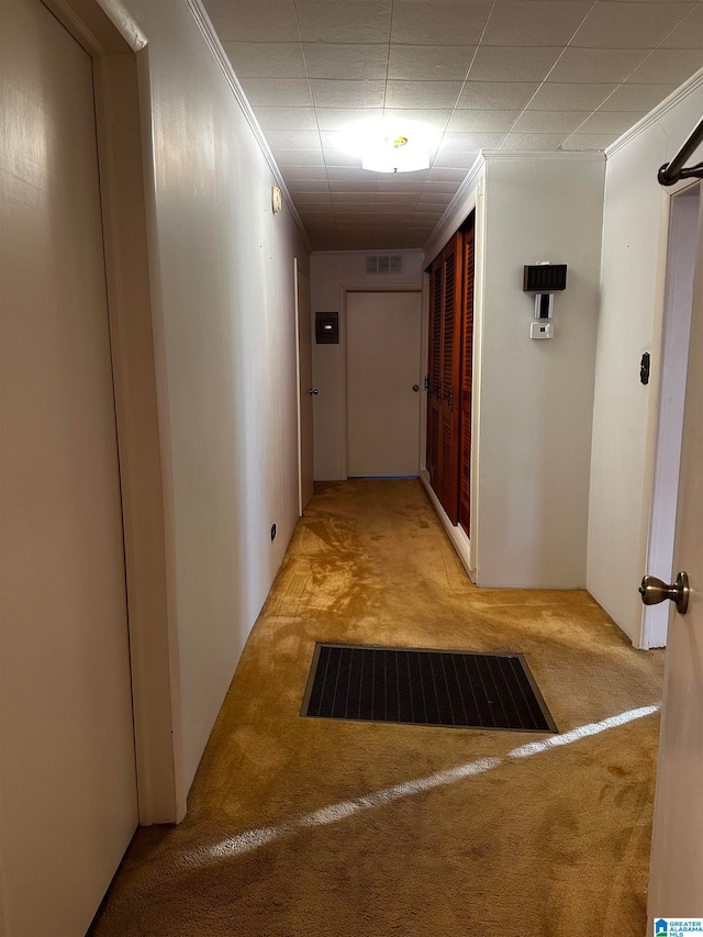 corridor with ornamental molding and light carpet