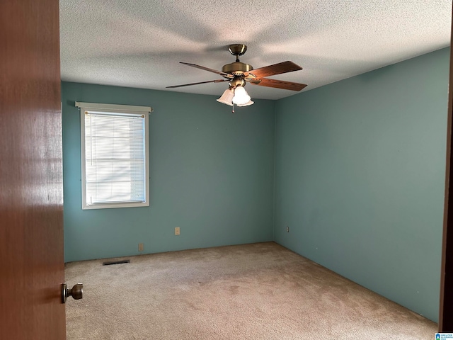 unfurnished room featuring ceiling fan, carpet floors, and a textured ceiling