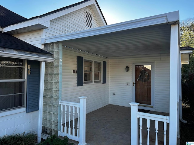 view of exterior entry featuring covered porch