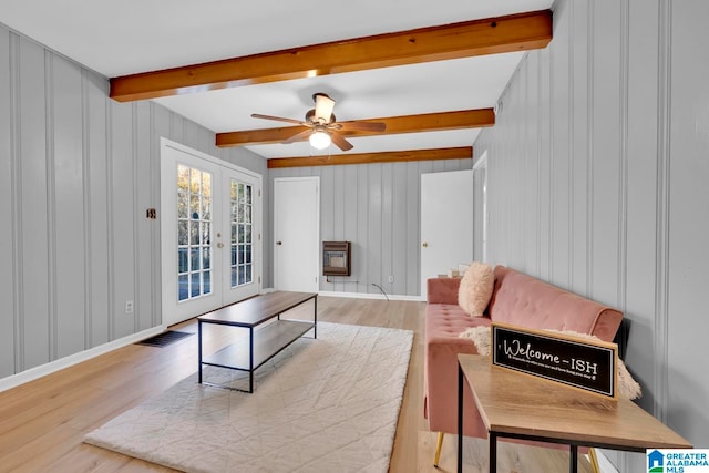 living room featuring beamed ceiling, ceiling fan, french doors, and light hardwood / wood-style flooring