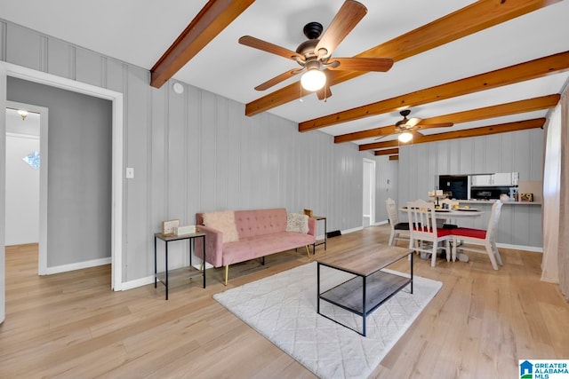 living room featuring beamed ceiling, light wood-type flooring, and ceiling fan