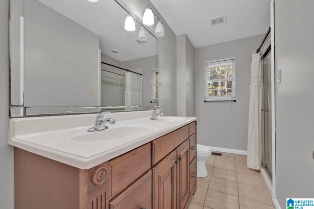 bathroom with tile patterned floors, vanity, toilet, and walk in shower