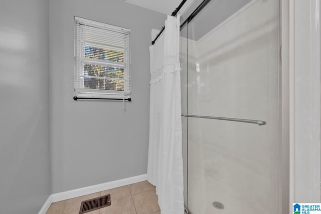 bathroom with tile patterned floors and walk in shower