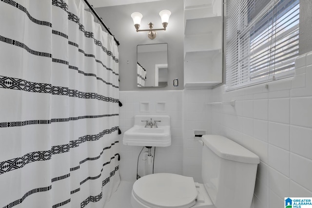 bathroom with toilet and tile walls