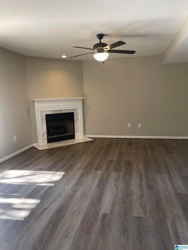 unfurnished living room featuring ceiling fan, dark hardwood / wood-style flooring, and a high end fireplace