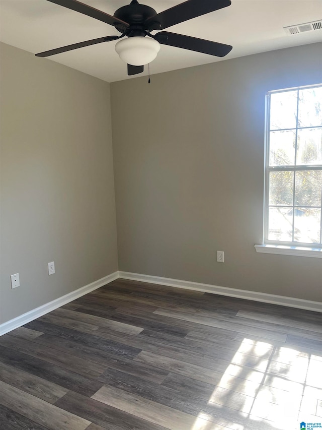 spare room with plenty of natural light, dark wood-type flooring, and ceiling fan