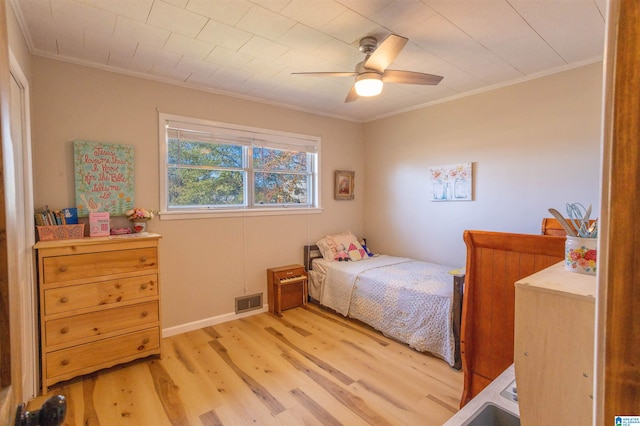 bedroom with ceiling fan, light hardwood / wood-style floors, and crown molding