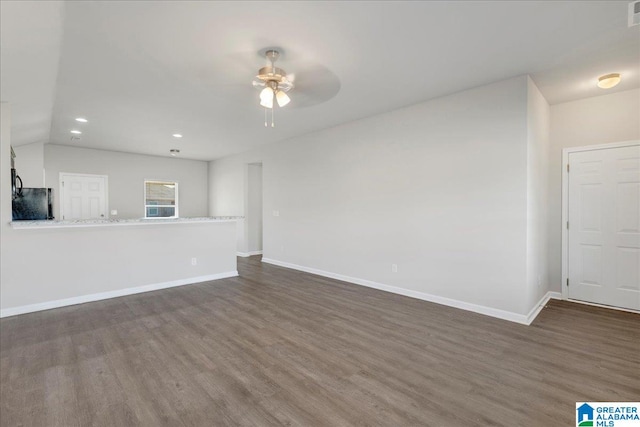 unfurnished living room with dark hardwood / wood-style floors, vaulted ceiling, and ceiling fan