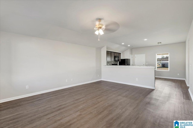 unfurnished living room with ceiling fan, dark wood-type flooring, and lofted ceiling