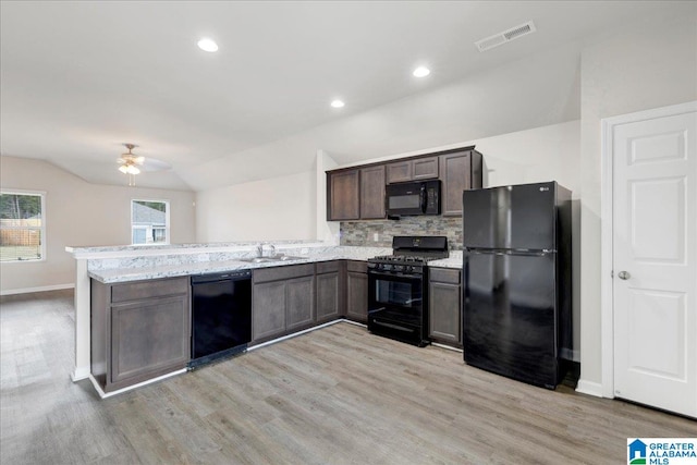 kitchen with lofted ceiling, black appliances, dark brown cabinets, light hardwood / wood-style floors, and kitchen peninsula