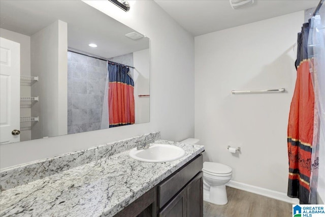 bathroom with hardwood / wood-style floors, vanity, a shower with shower curtain, and toilet