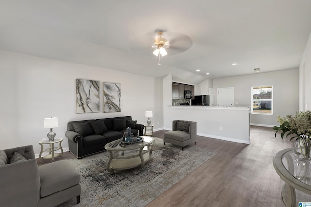 living room featuring lofted ceiling, ceiling fan, and dark hardwood / wood-style floors