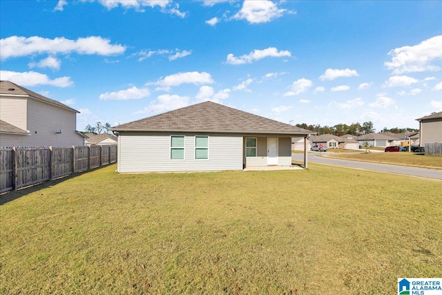 rear view of house featuring a yard