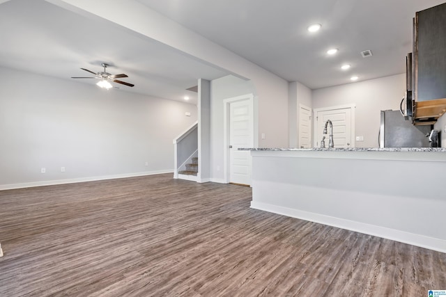 unfurnished living room with ceiling fan, dark hardwood / wood-style flooring, and sink