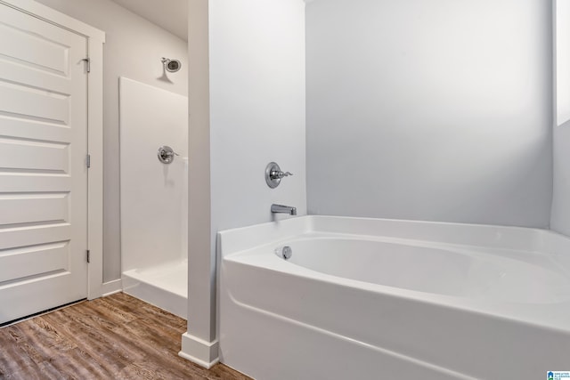 bathroom with a washtub and hardwood / wood-style flooring