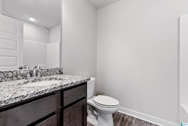 bathroom with vanity, wood-type flooring, and toilet