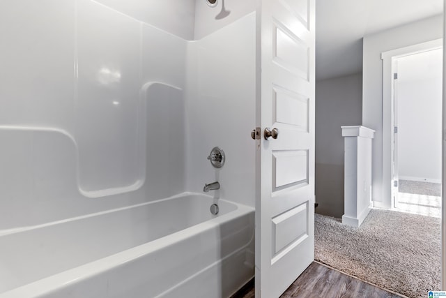 bathroom with hardwood / wood-style floors and bathtub / shower combination