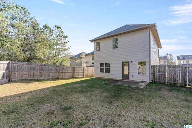 rear view of house featuring a yard and a patio area