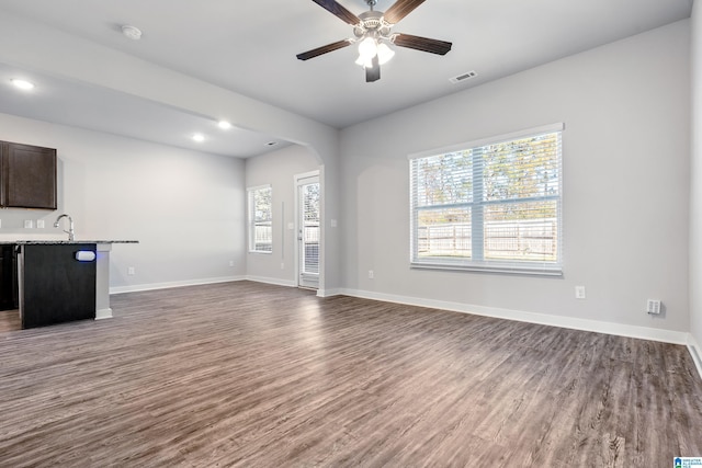 unfurnished living room with dark hardwood / wood-style floors, ceiling fan, and sink