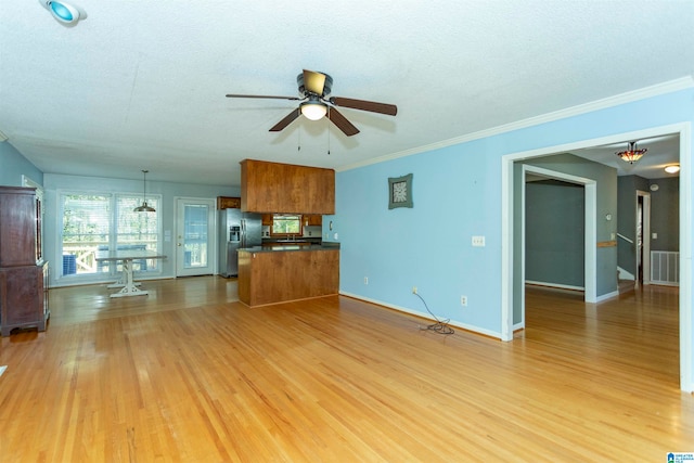 unfurnished living room with a textured ceiling, light wood-type flooring, ceiling fan, and crown molding