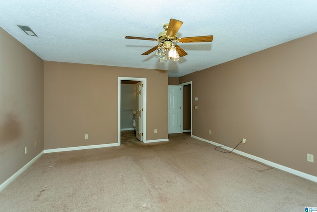 unfurnished bedroom featuring ceiling fan, a spacious closet, light carpet, and a closet