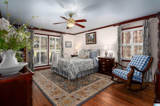 bedroom featuring hardwood / wood-style floors, ceiling fan, and crown molding