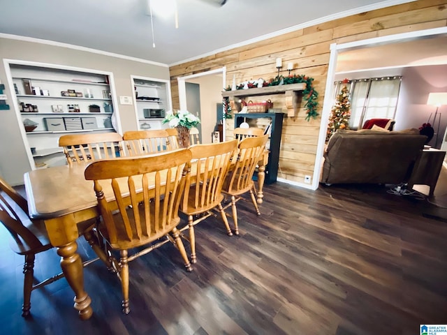 dining room with dark hardwood / wood-style flooring, built in features, ornamental molding, and wood walls