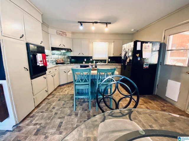 kitchen featuring tasteful backsplash, ornamental molding, black appliances, a center island, and white cabinetry