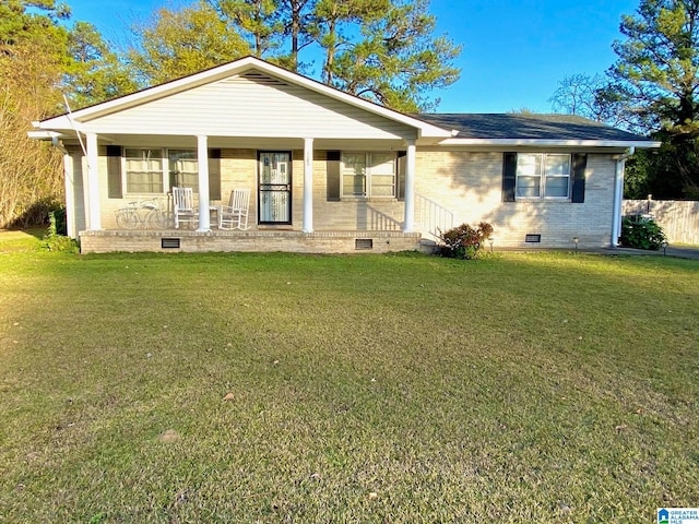 ranch-style house featuring covered porch and a front yard