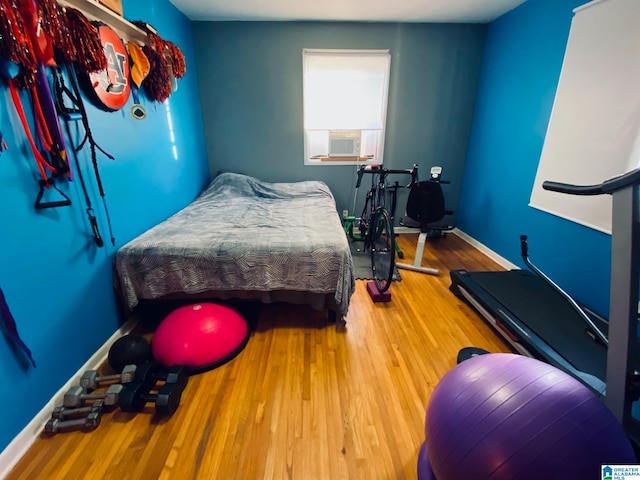 bedroom featuring hardwood / wood-style floors and cooling unit