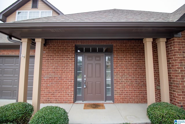 view of exterior entry with a garage and covered porch