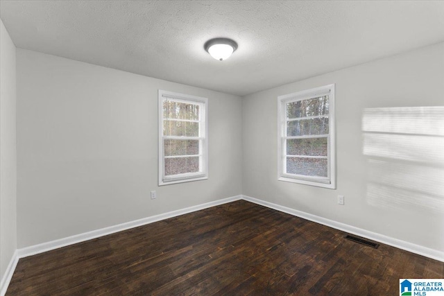 spare room with wood-type flooring and a textured ceiling