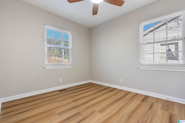 spare room featuring light hardwood / wood-style floors, plenty of natural light, and ceiling fan