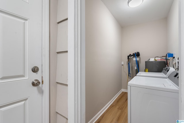 laundry area with independent washer and dryer and light hardwood / wood-style flooring