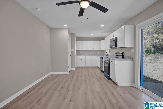 kitchen featuring appliances with stainless steel finishes, light wood-type flooring, ceiling fan, sink, and white cabinets