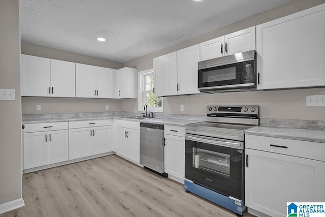 6129 Spruce Dr, Anniston, AL 36206 - kitchen featuring appliances with stainless steel finishes, a sink, light wood-style floors, light countertops, and recessed lighting