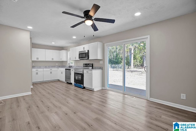 kitchen with white cabinets, ceiling fan, a textured ceiling, appliances with stainless steel finishes, and light hardwood / wood-style floors