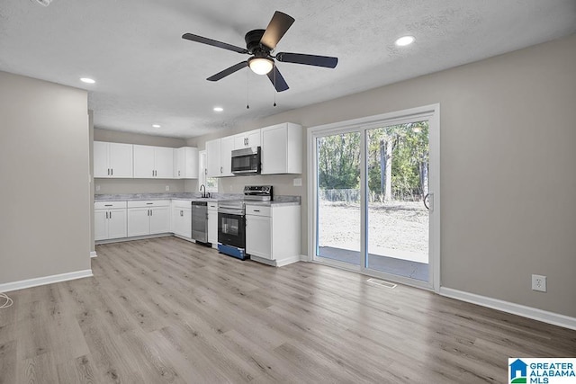 6129 Spruce Dr, Anniston, AL 36206 - kitchen with appliances with stainless steel finishes, light wood-type flooring, a sink, baseboards, and light countertops