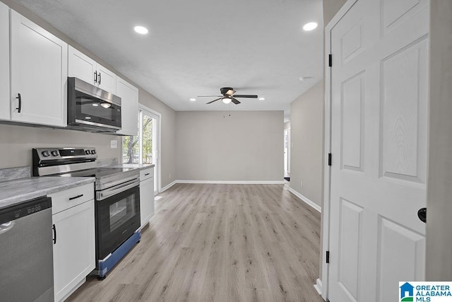 6129 Spruce Dr, Anniston, AL 36206 - kitchen with stainless steel appliances, ceiling fan, light wood finished floors, white cabinets, and baseboards