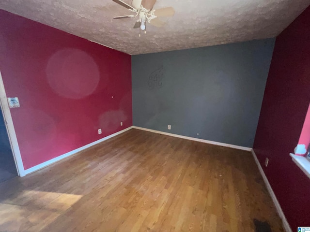 spare room with hardwood / wood-style flooring, a textured ceiling, and vaulted ceiling