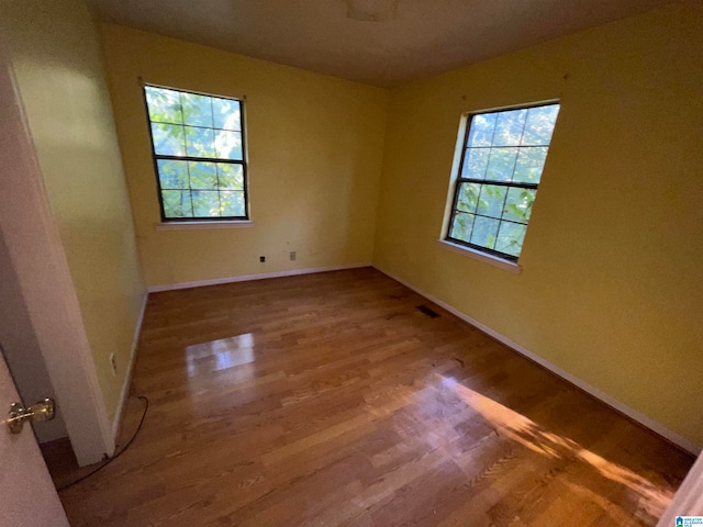 unfurnished room with hardwood / wood-style flooring