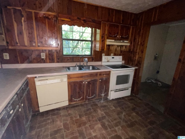 kitchen featuring wood walls, sink, and white appliances