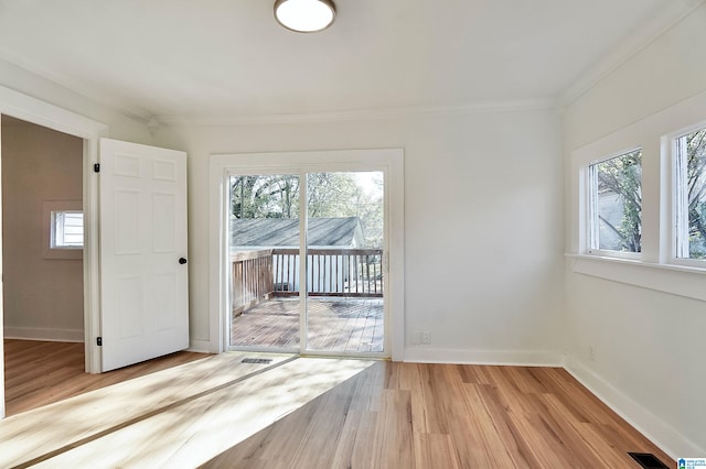 spare room with crown molding and light hardwood / wood-style flooring