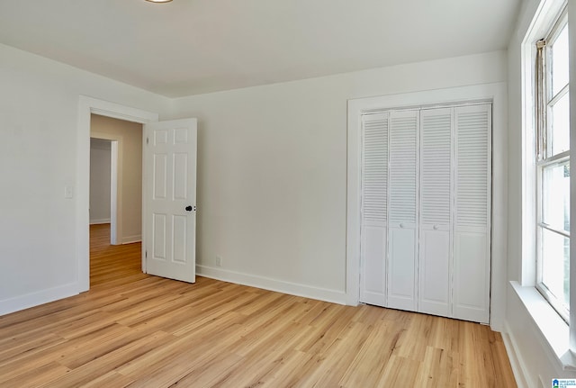 unfurnished bedroom with a closet and light hardwood / wood-style flooring