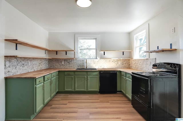 kitchen featuring green cabinets, a wealth of natural light, black appliances, and light wood-type flooring