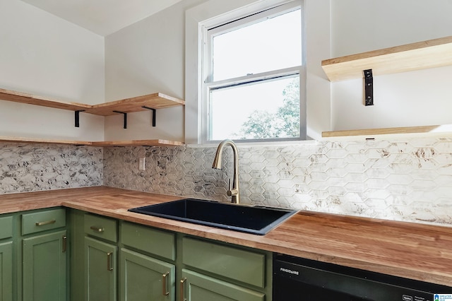 kitchen with wooden counters, dishwasher, green cabinets, and sink