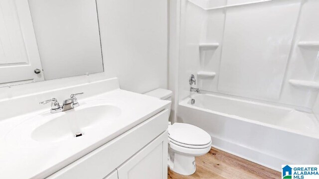 full bathroom with bathtub / shower combination, hardwood / wood-style floors, vanity, and toilet