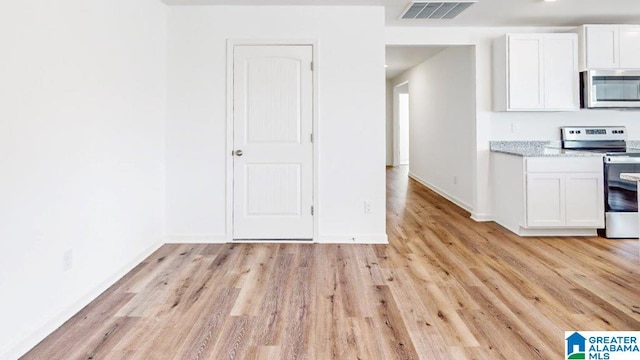 kitchen featuring white cabinets, stainless steel appliances, and light wood-type flooring