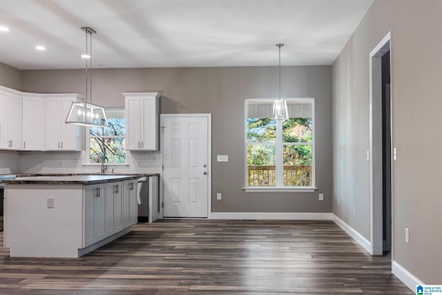 kitchen featuring a wealth of natural light, dark wood-type flooring, white cabinets, and hanging light fixtures